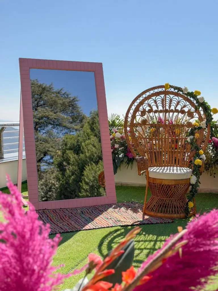 Floral-trimmed wicker chair and pink mirror in the mehendi lounge at Royal Orchid Fort Resort