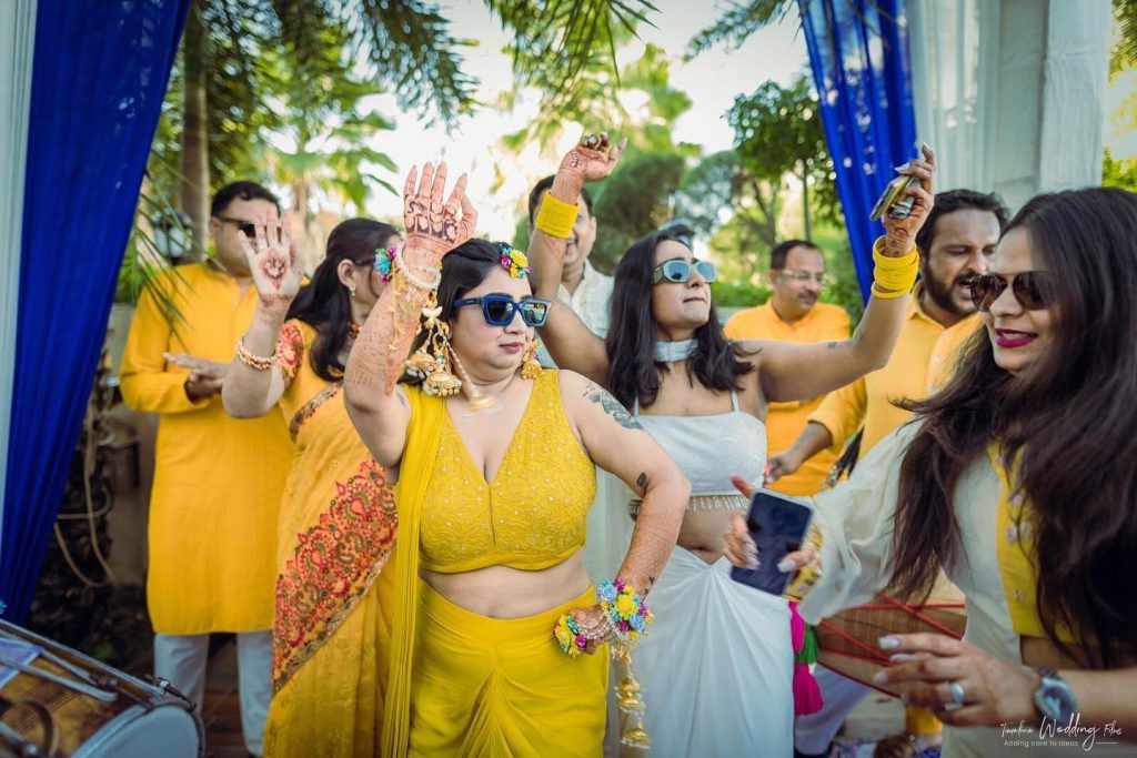 Haldi guests dancing between blue drapes