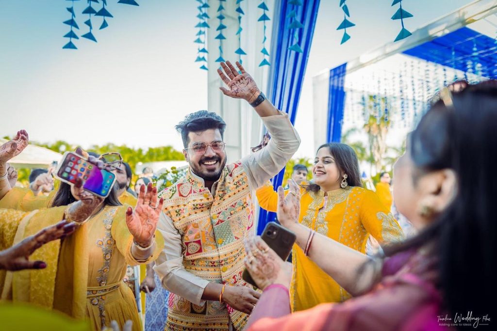 Family celebration beneath hanging blue details at the haldi