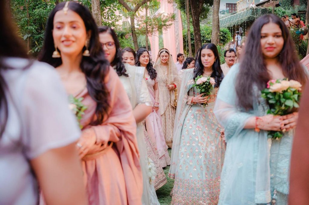 Rashi entering the Shaheen Bagh garden with friends carrying floral bouquets