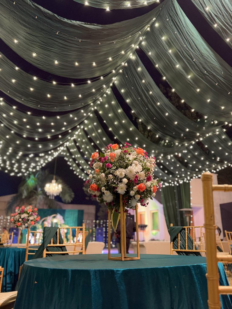 Pink and white flowers above green tablecloths and matching chair sashes.